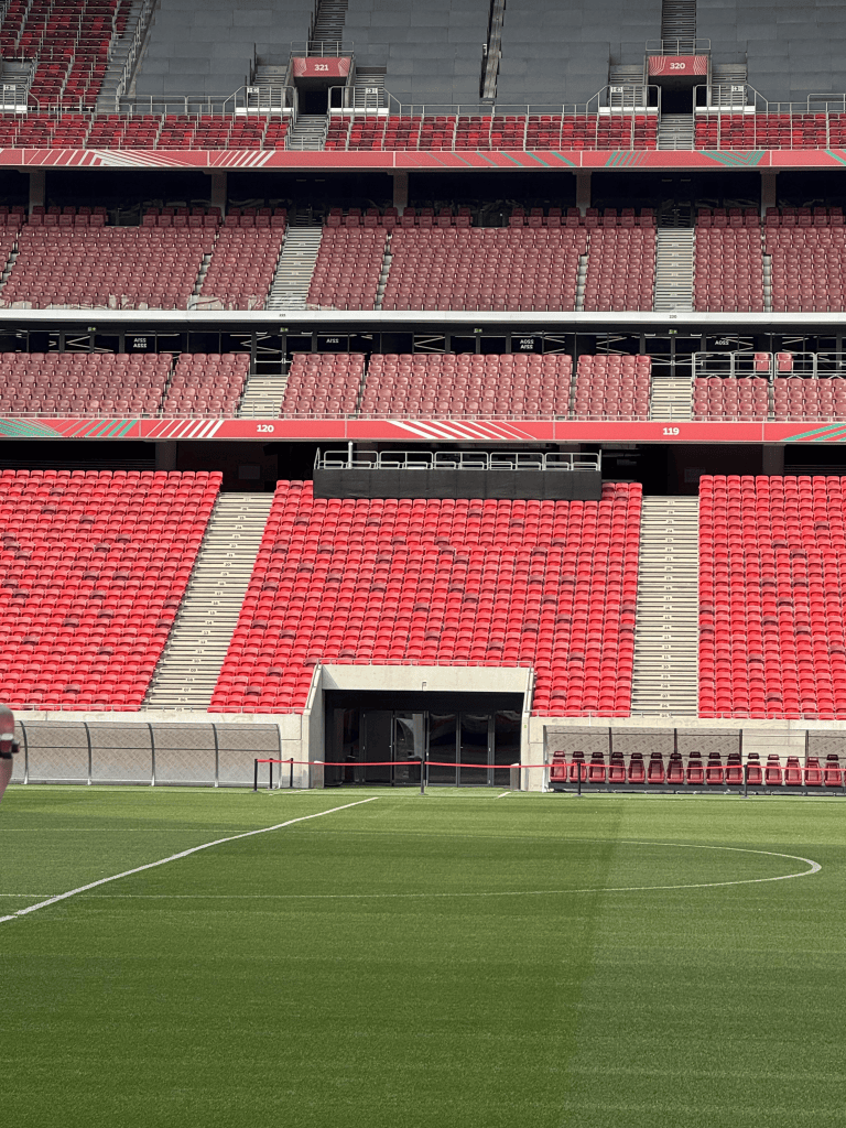 Red seating above an entrance opposite the Puskás Aréna pitch.