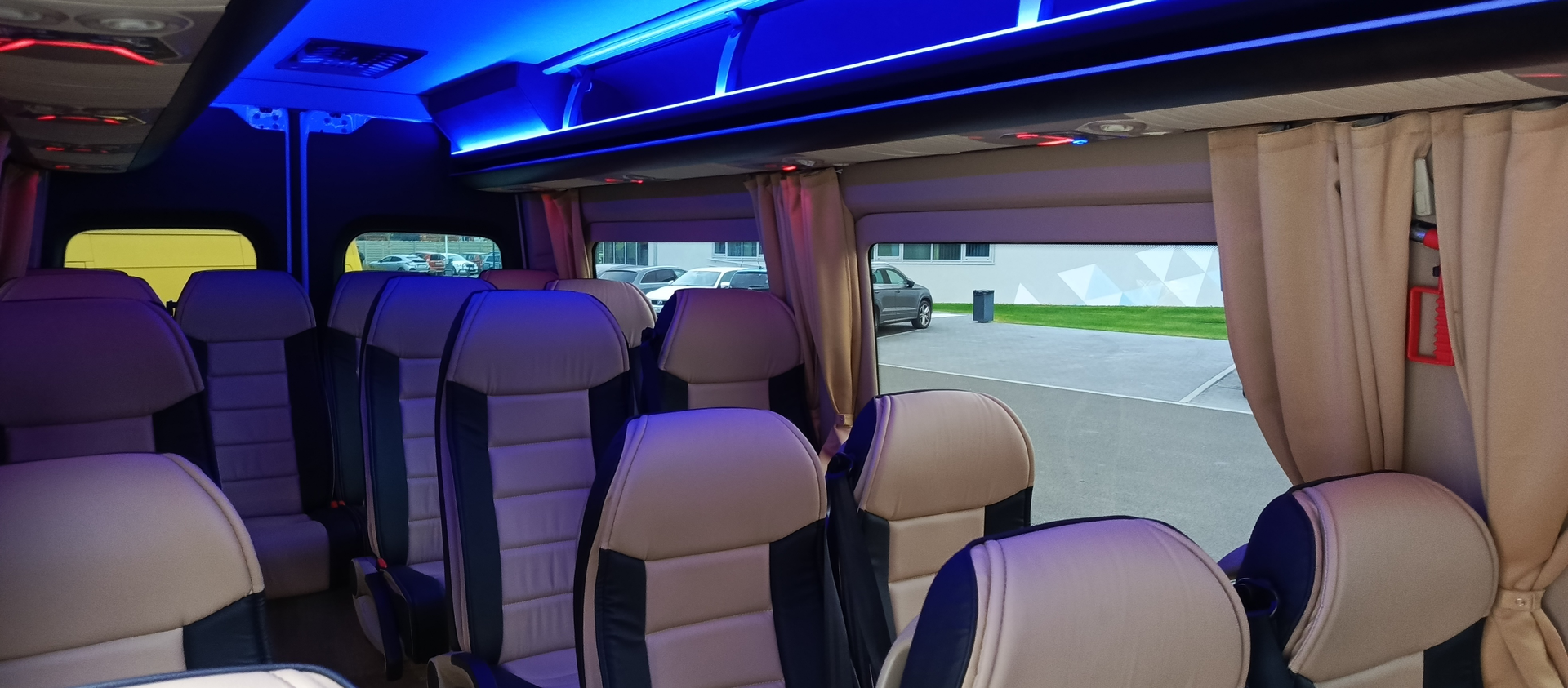 Coach-style cabin in cream and navy beneath soft blue ambient lighting