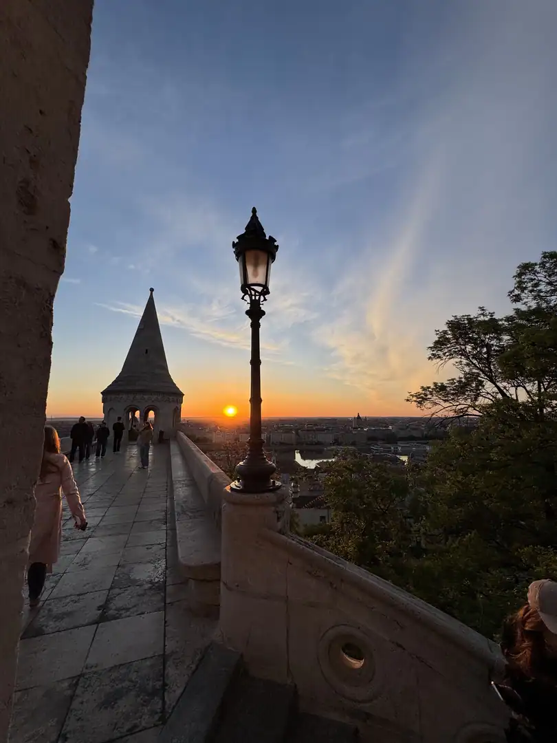 Fisherman’s Bastion terrace with a stone tower, streetlamp and low sun above Budapest