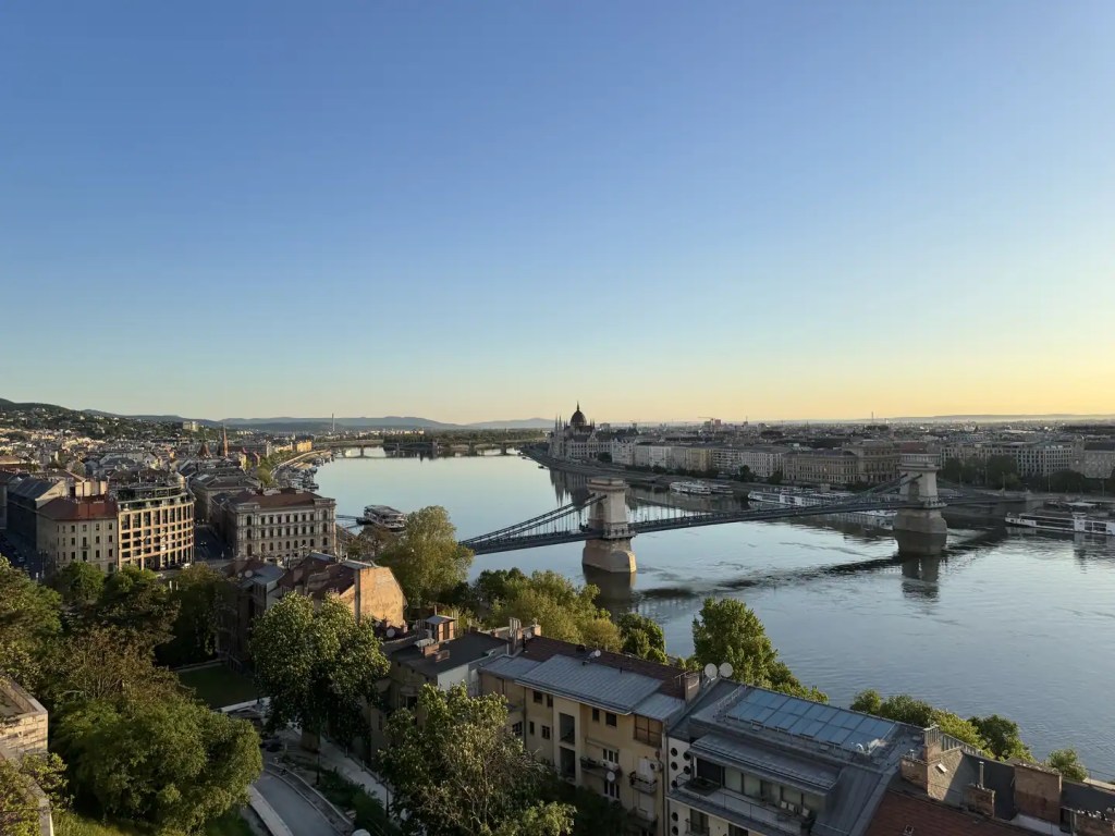 Chain Bridge and Budapest cityscape beside the Danube at sunset.