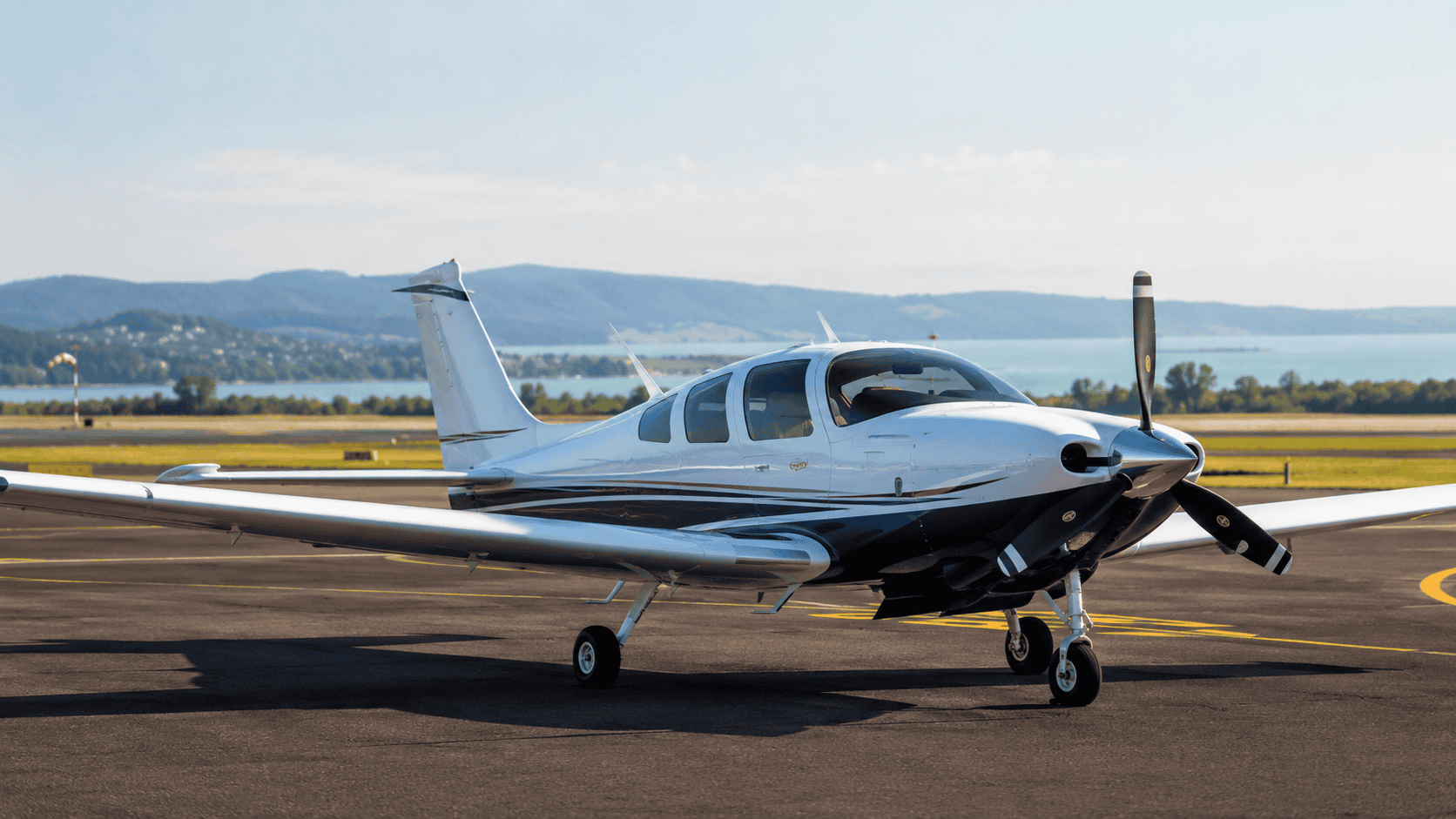 Twin-engine aircraft at Hévíz–Balaton Airport with Lake Balaton in the background