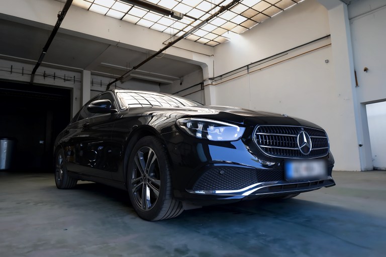 Black Mercedes E-Class sedan, three-quarter front view