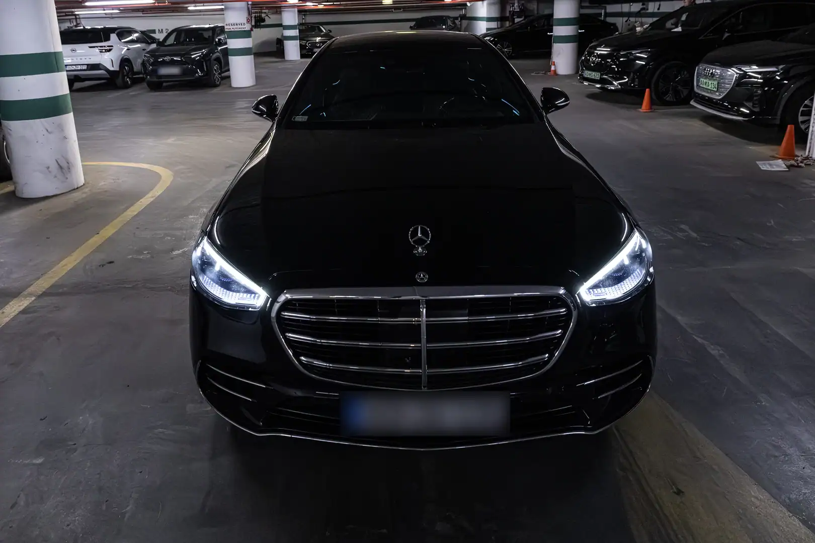 Black Mercedes-Benz S-Class with headlights on