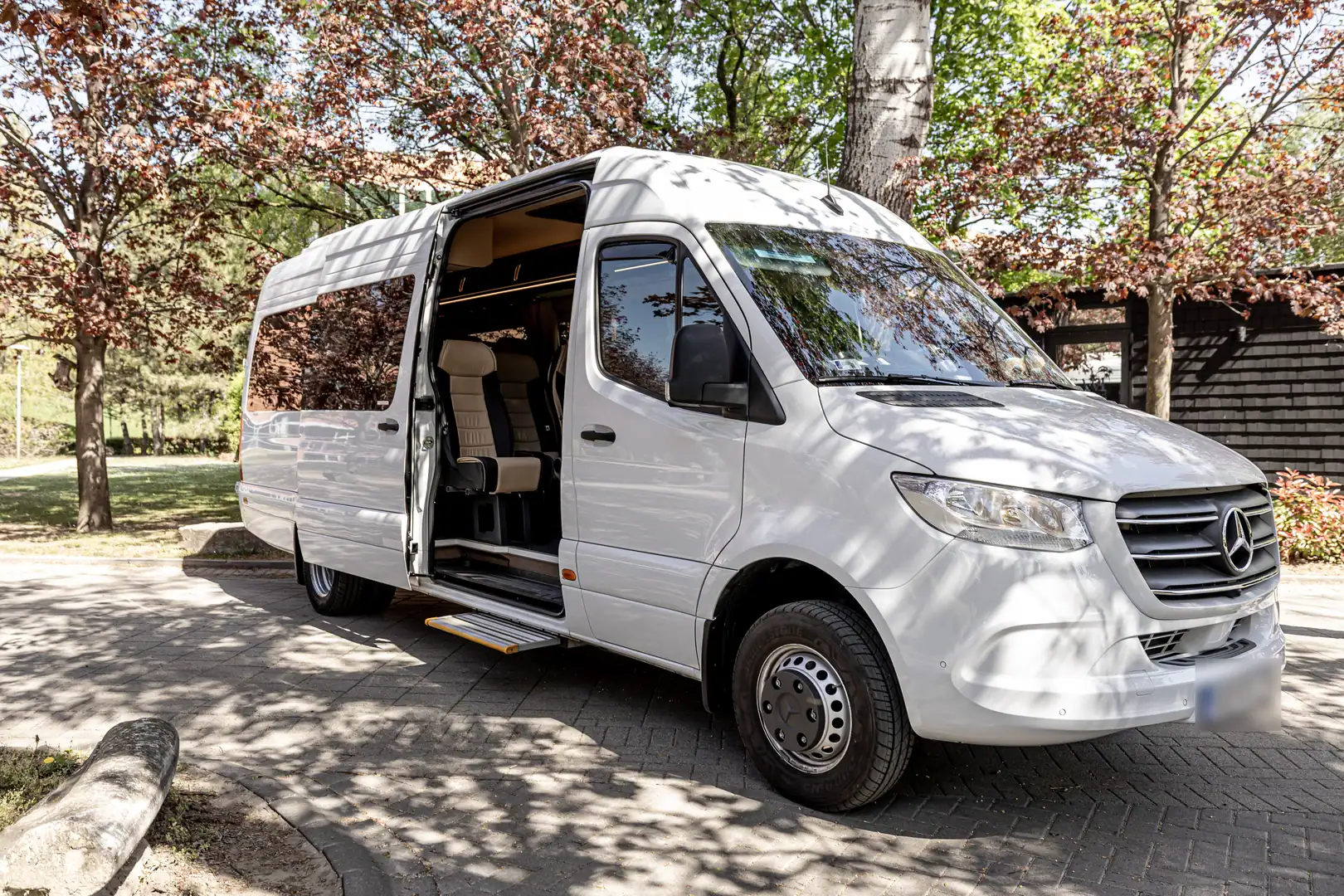 The white Mercedes-Benz Sprinter with its side door open