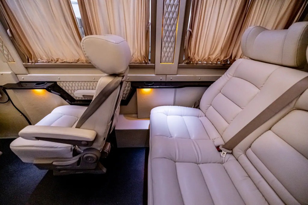 Cream leather captain’s chairs and curtains inside a Mercedes-Benz Sprinter
