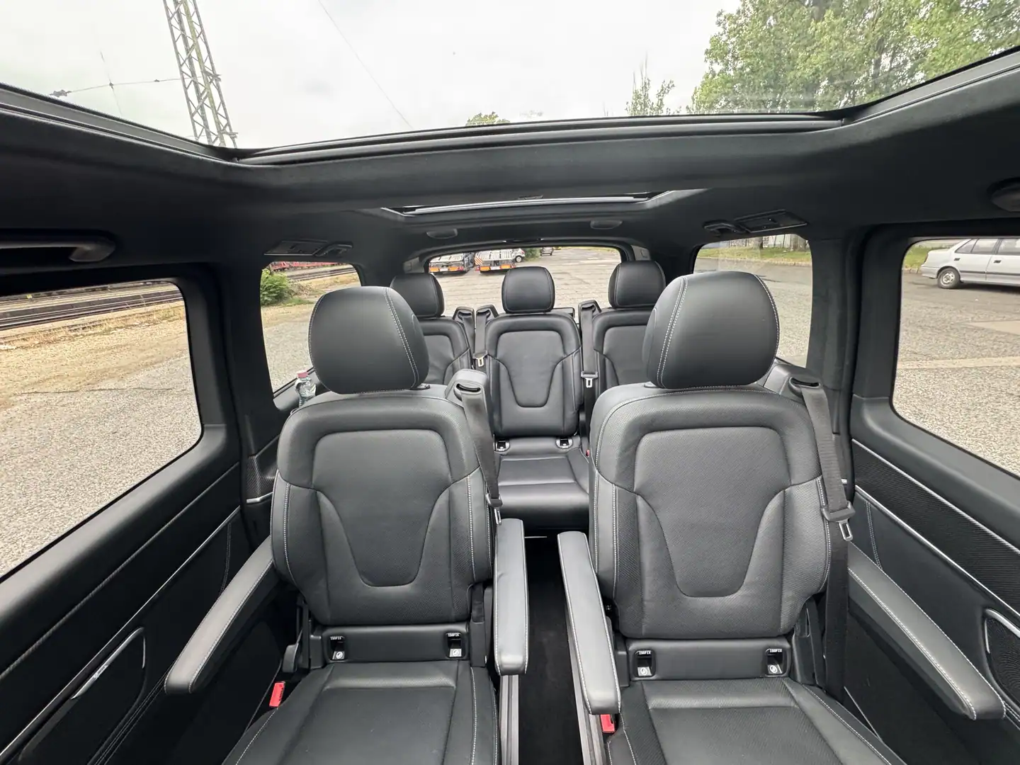 Passenger seats and panoramic glass roof inside a Mercedes-Benz V-Class.