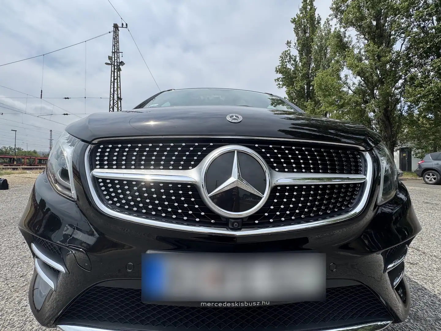 Frontgrill und Scheinwerfer eines schwarzen Mercedes-Benz V-Class.