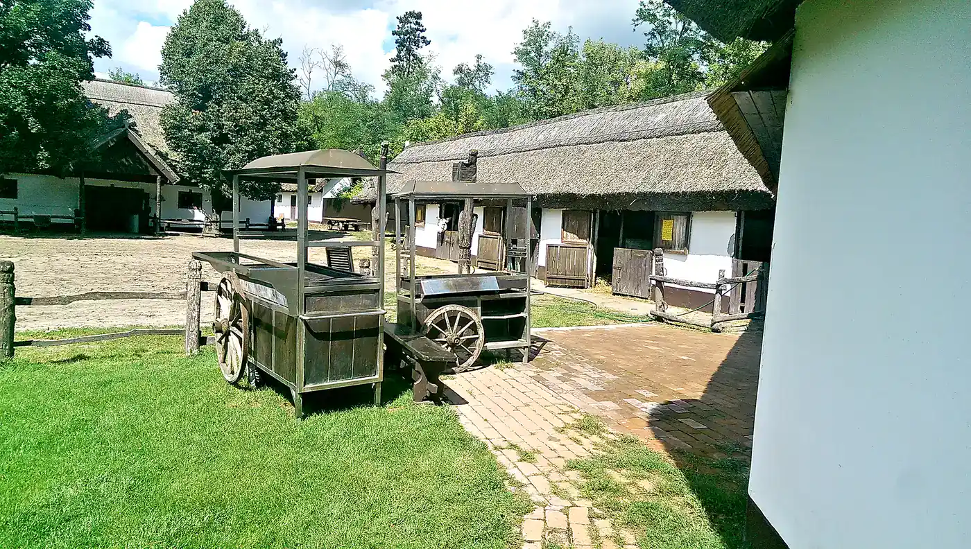 Traditional wooden cart beside the thatched stables of a Puszta farm