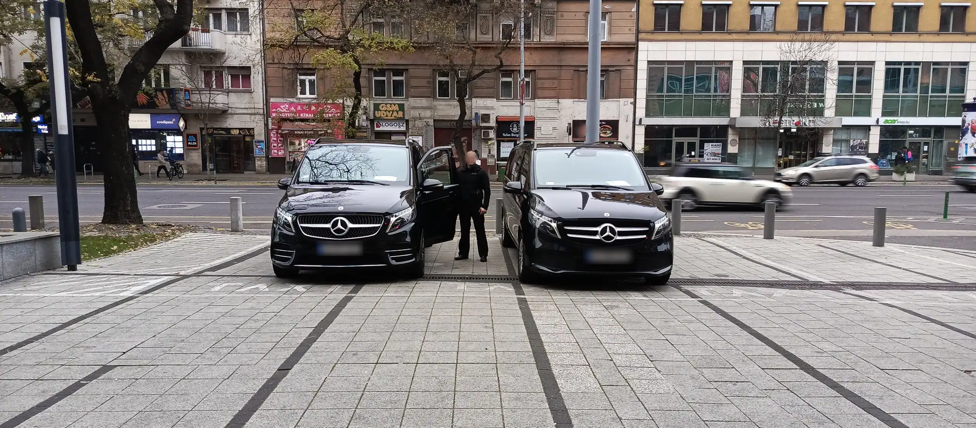 Two Mercedes-Benz V-Class vehicles parked in a city square