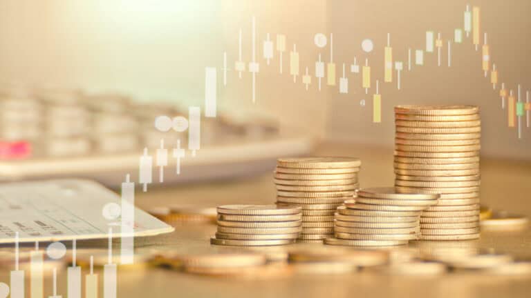Coins stacked with stock market graph in the background.