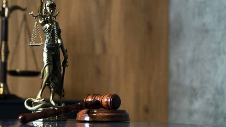 Justice Lady statue holding scales and gavel, symbolizing legal fairness.