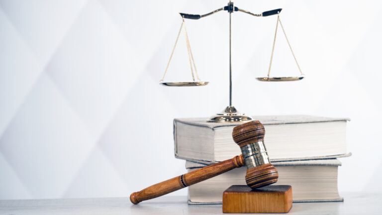 Legal gavel, scales of justice, and law books on a desk.