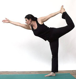 Woman practicing yoga balance pose, demonstrating flexibility and focus.