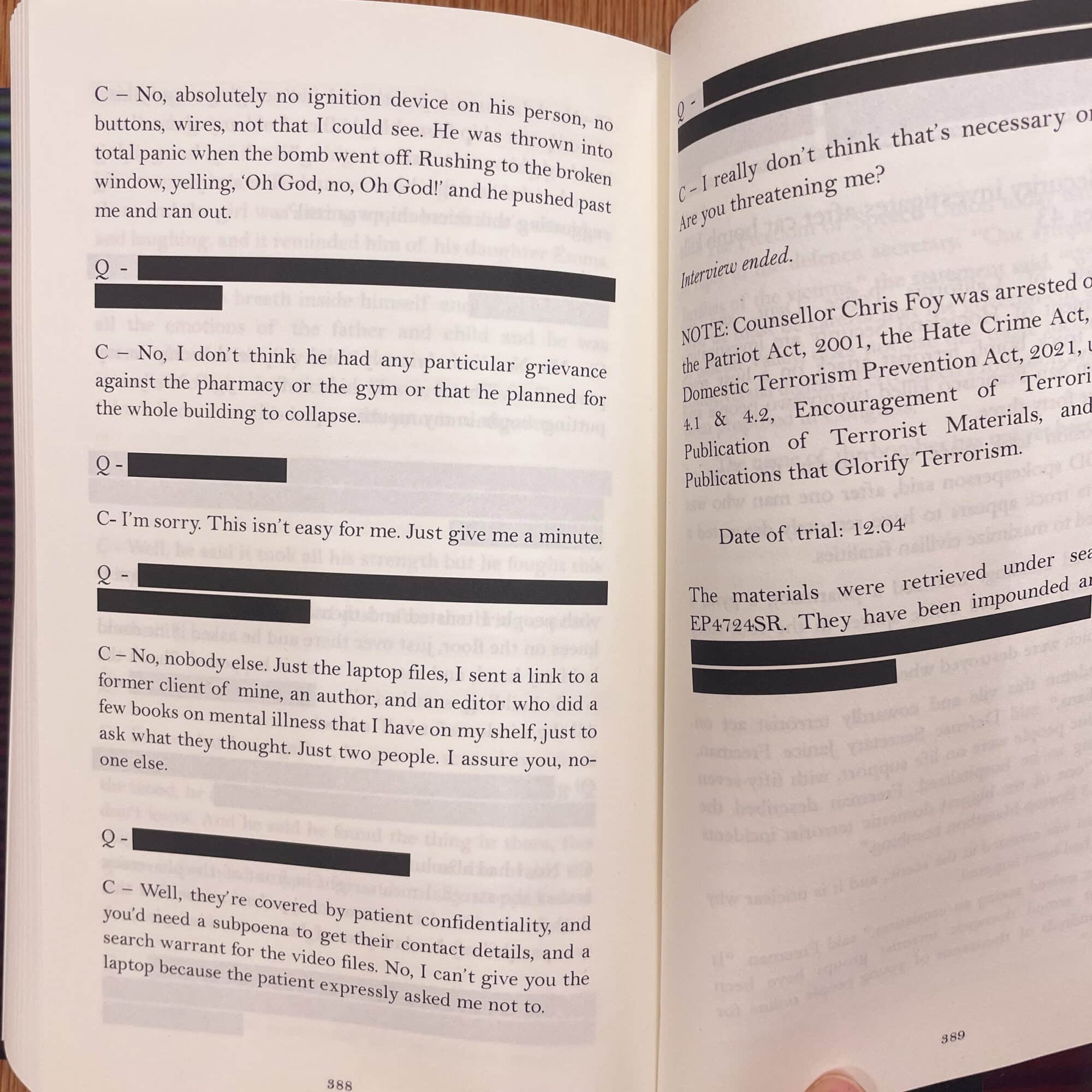Page from a book showing a conversation about a bomb and a laptop, with blacked-out sections.