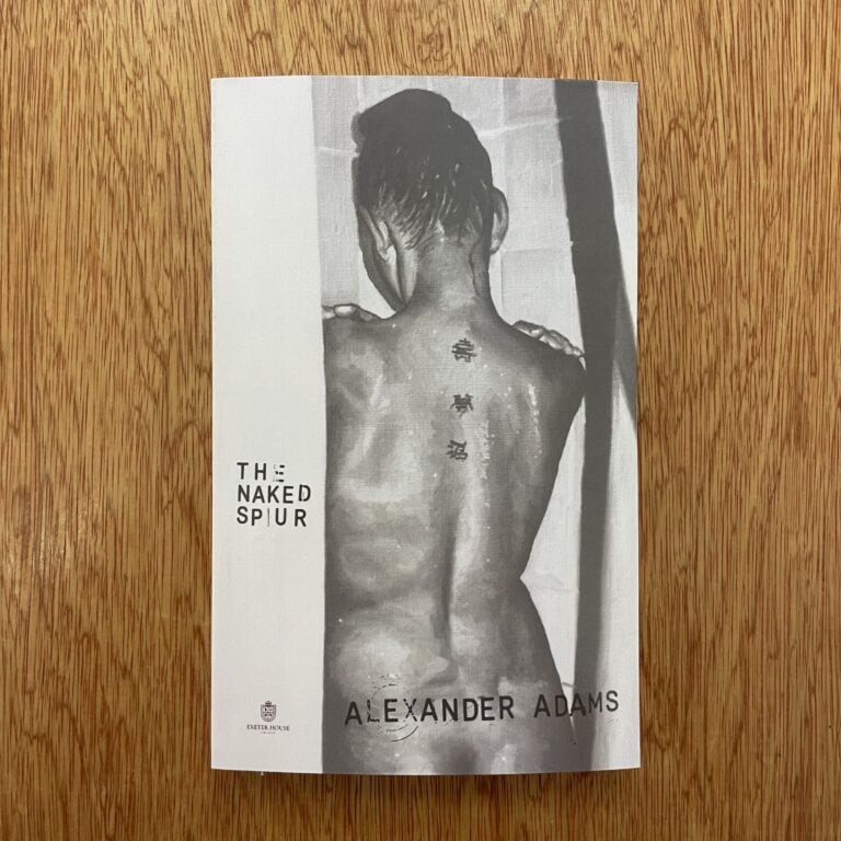 Black and white image of a woman with her back turned, showing tattoos on her back, with the title 'The Naked Spur' and artist's name Alexander Adams.