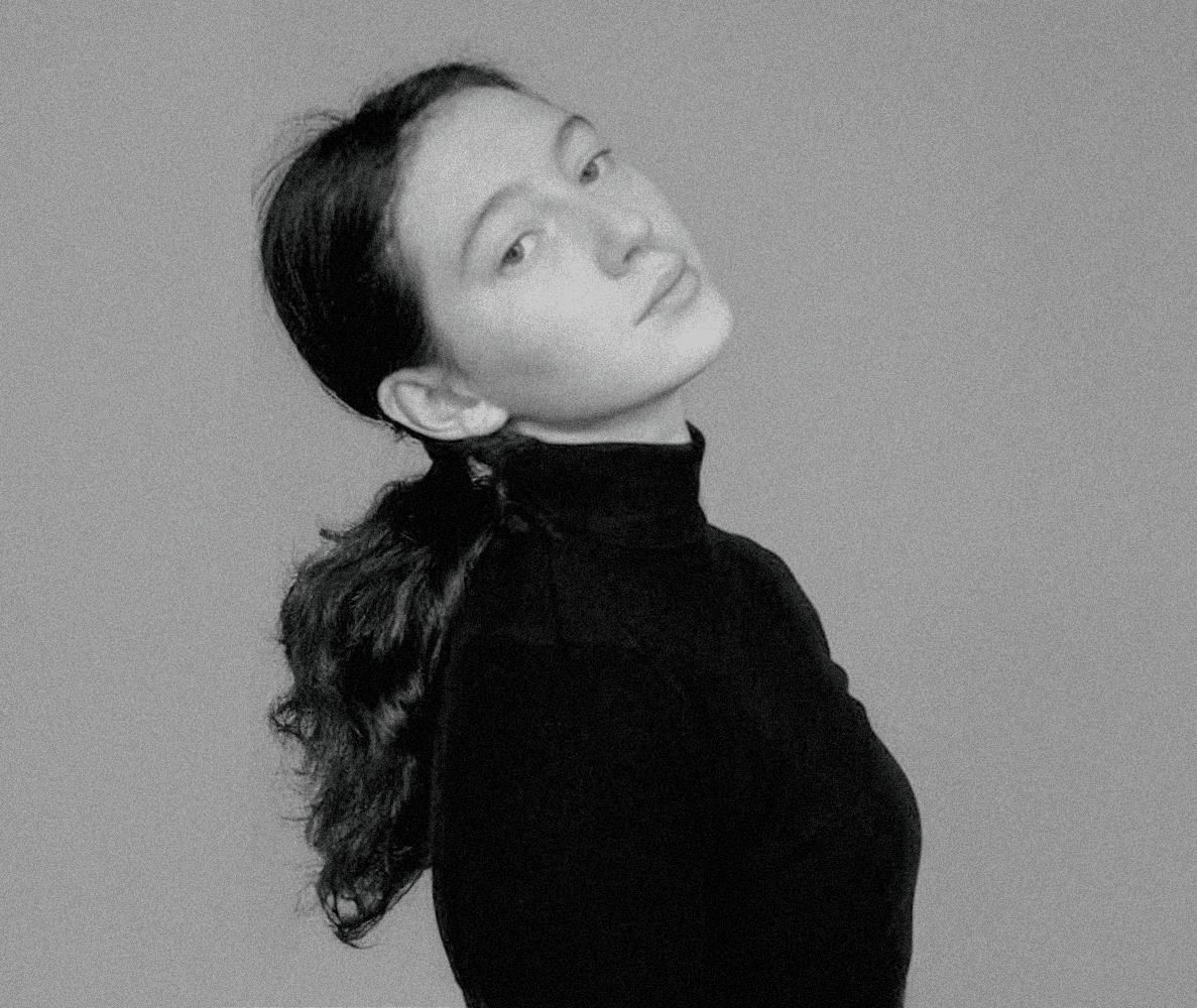Black and white portrait of a woman with long wavy hair wearing a turtleneck sweater, minimalist style, elegant and sophisticated, high-contrast photography.