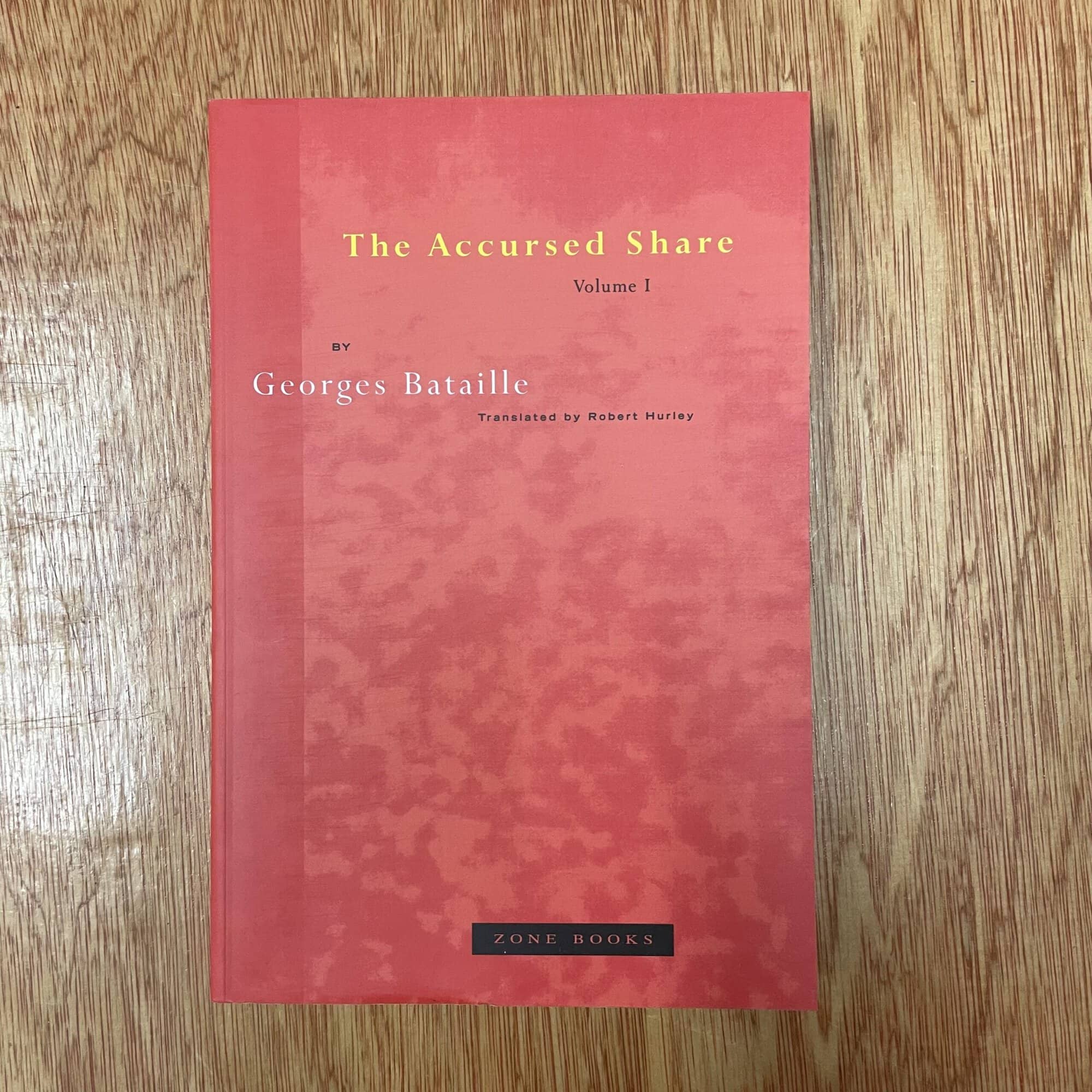 Cover of 'The Accursed Share Volume 1' by Georges Bataille, published by Zone Books, on a wooden surface.