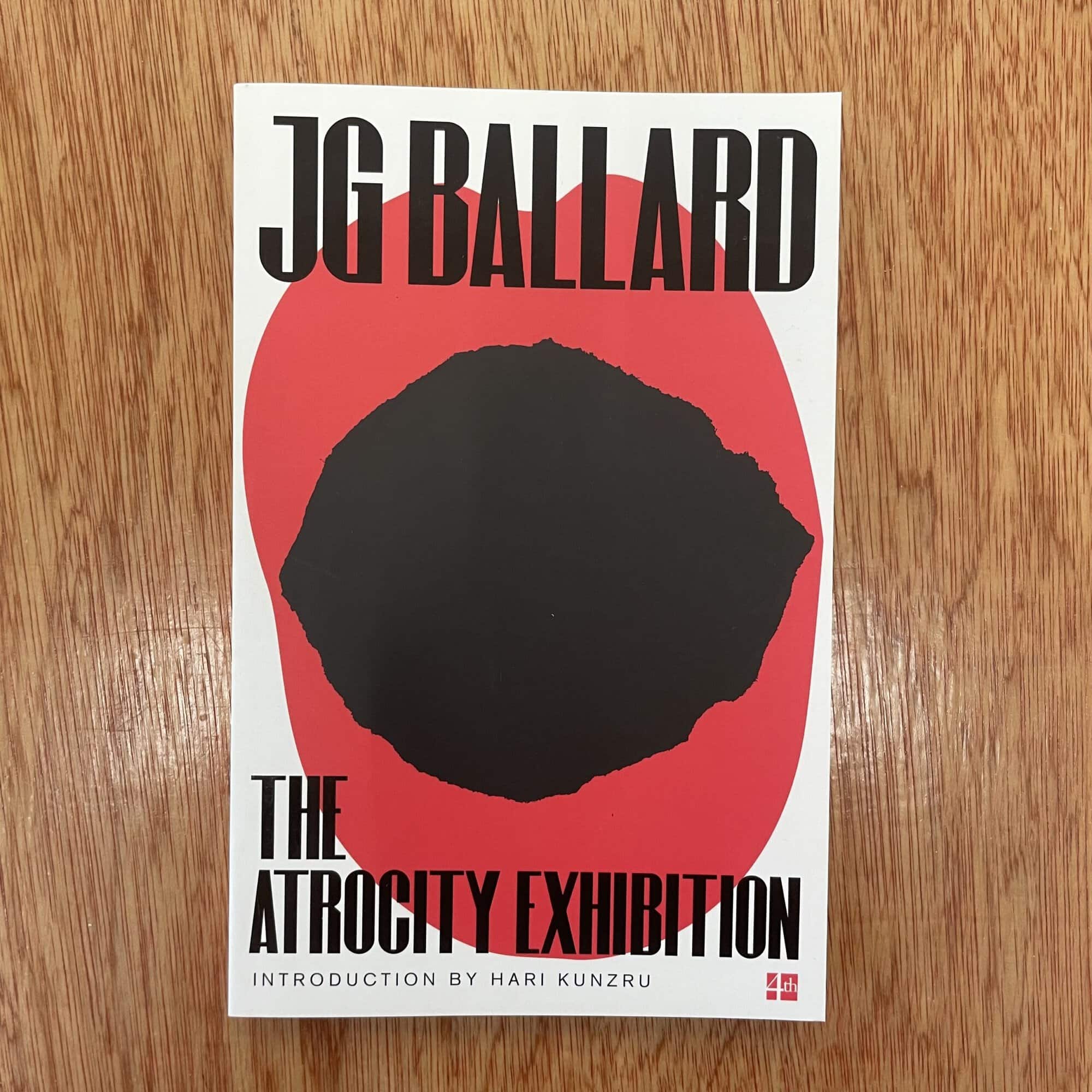 Cover of 'The Atrocity Exhibition' by J.G. Ballard featuring a black abstract shape on a red background.