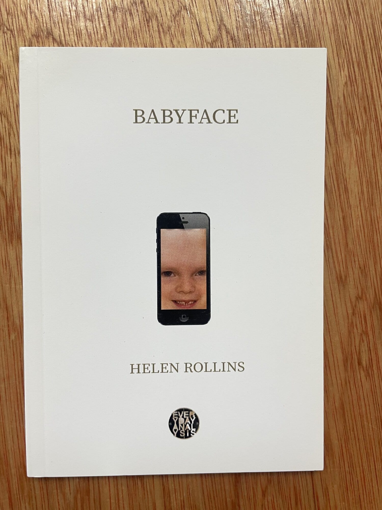 Cover of 'Babyface' by Helen Rollins featuring a smartphone with a child's face on the screen.