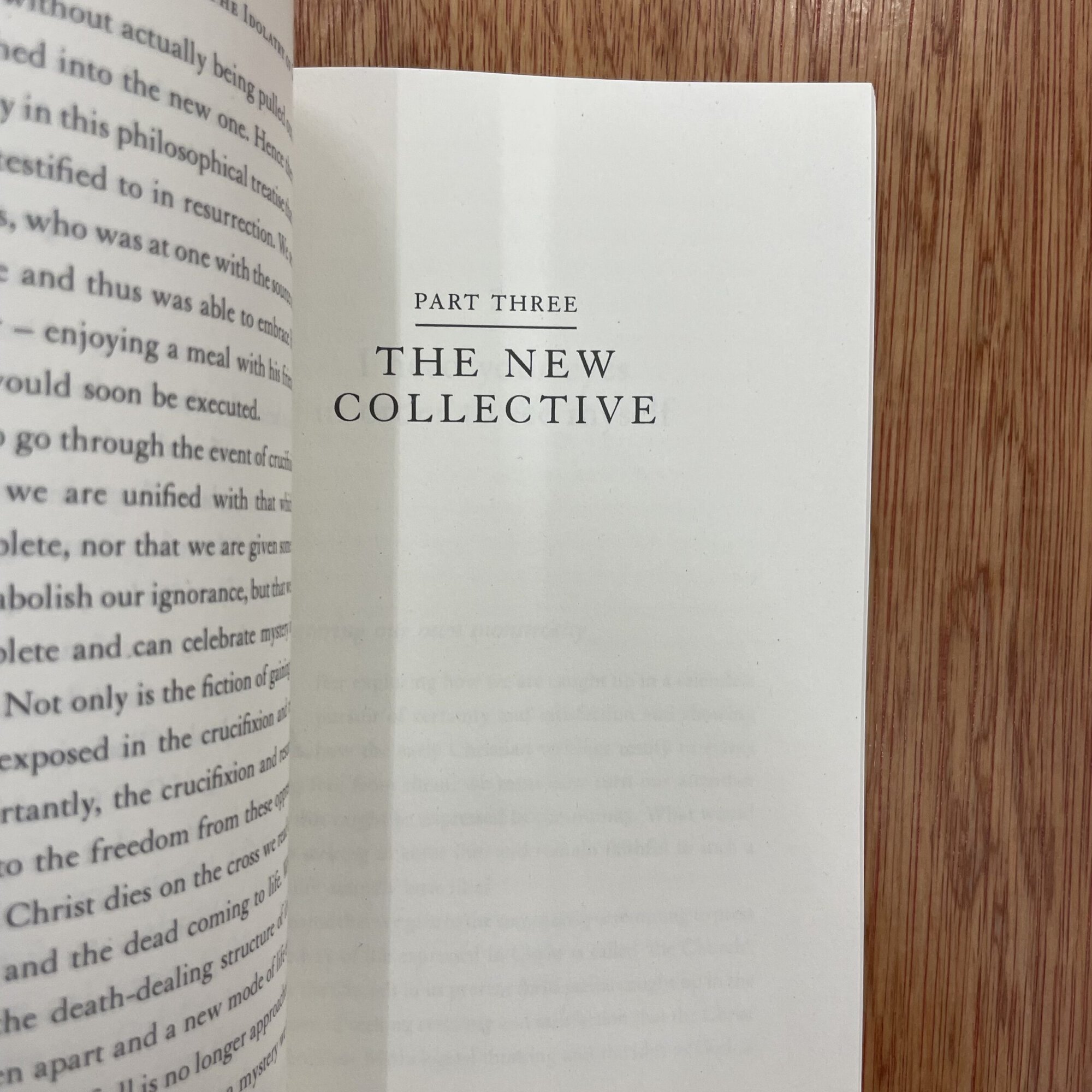 Open book showing 'Part Three The New Collective' on a wooden table, with a focus on the page layout and typography.