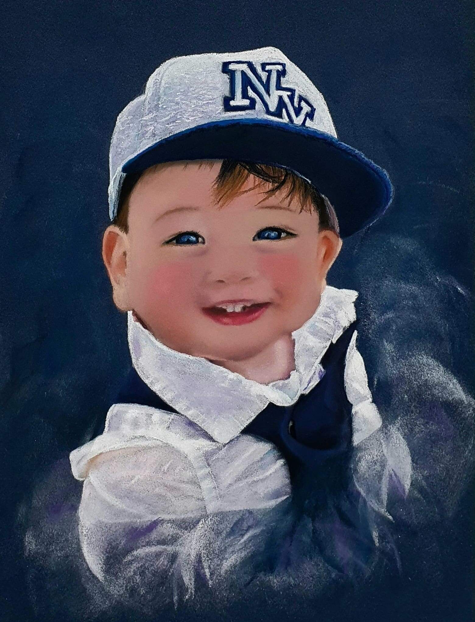 Child wearing a grey cap with "NM" logo and a white shirt.