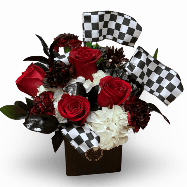 "Vegas Speedway Blossoms": A vibrant blend of red roses, black carnations, and white hydrangeas in a sleek black ceramic container adorned with checkered flags. The perfect Las Vegas Grand Prix centerpiece.