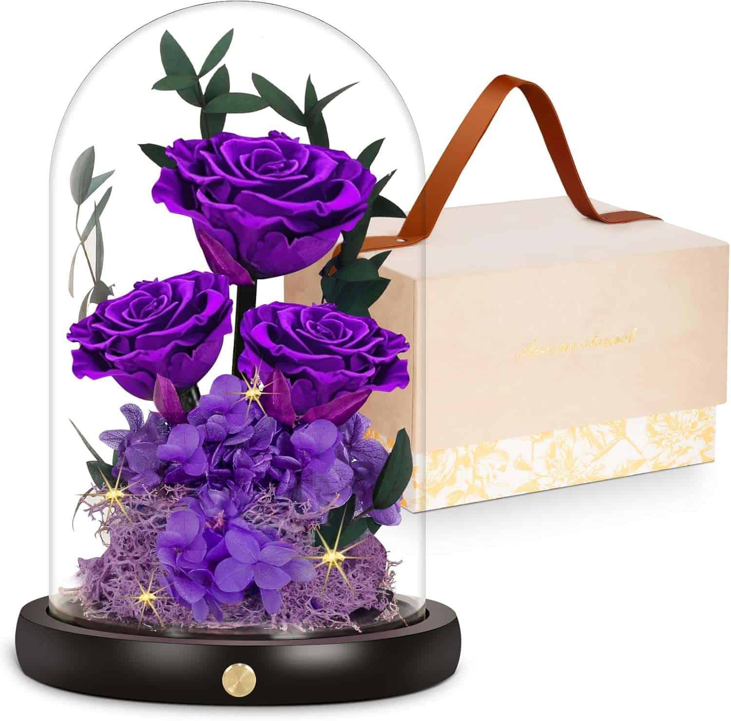 Vibrant purple roses and hydrangeas flower arrangement inside a glass dome with decorative greenery, presented with a stylish beige gift box with a brown handle for luxurious flower delivery in Las Vegas.