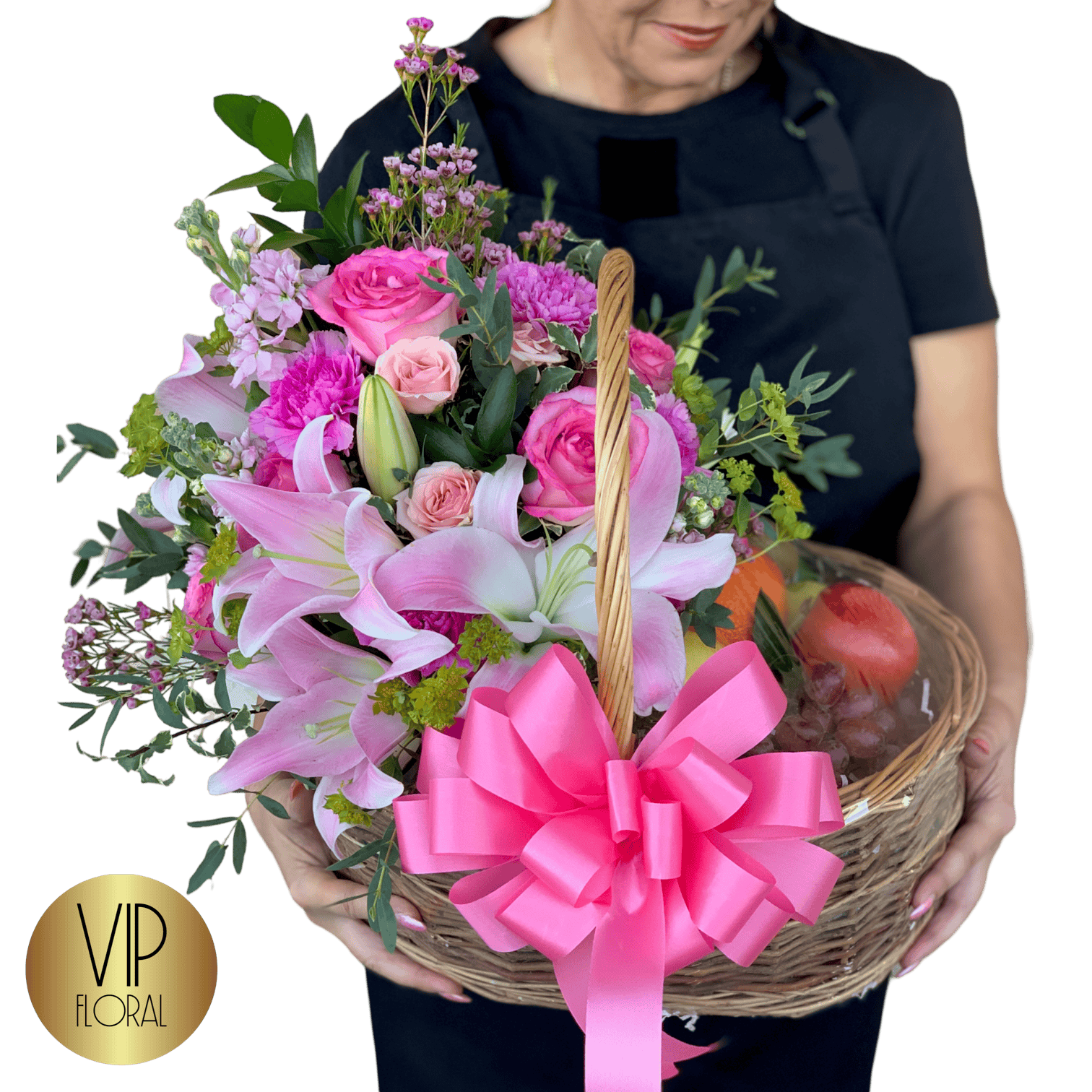 Pink floral arrangement with lilies, roses, and greenery in a wicker basket, accented with a large pink bow, ideal for special occasions or gifts from VIP Floral.