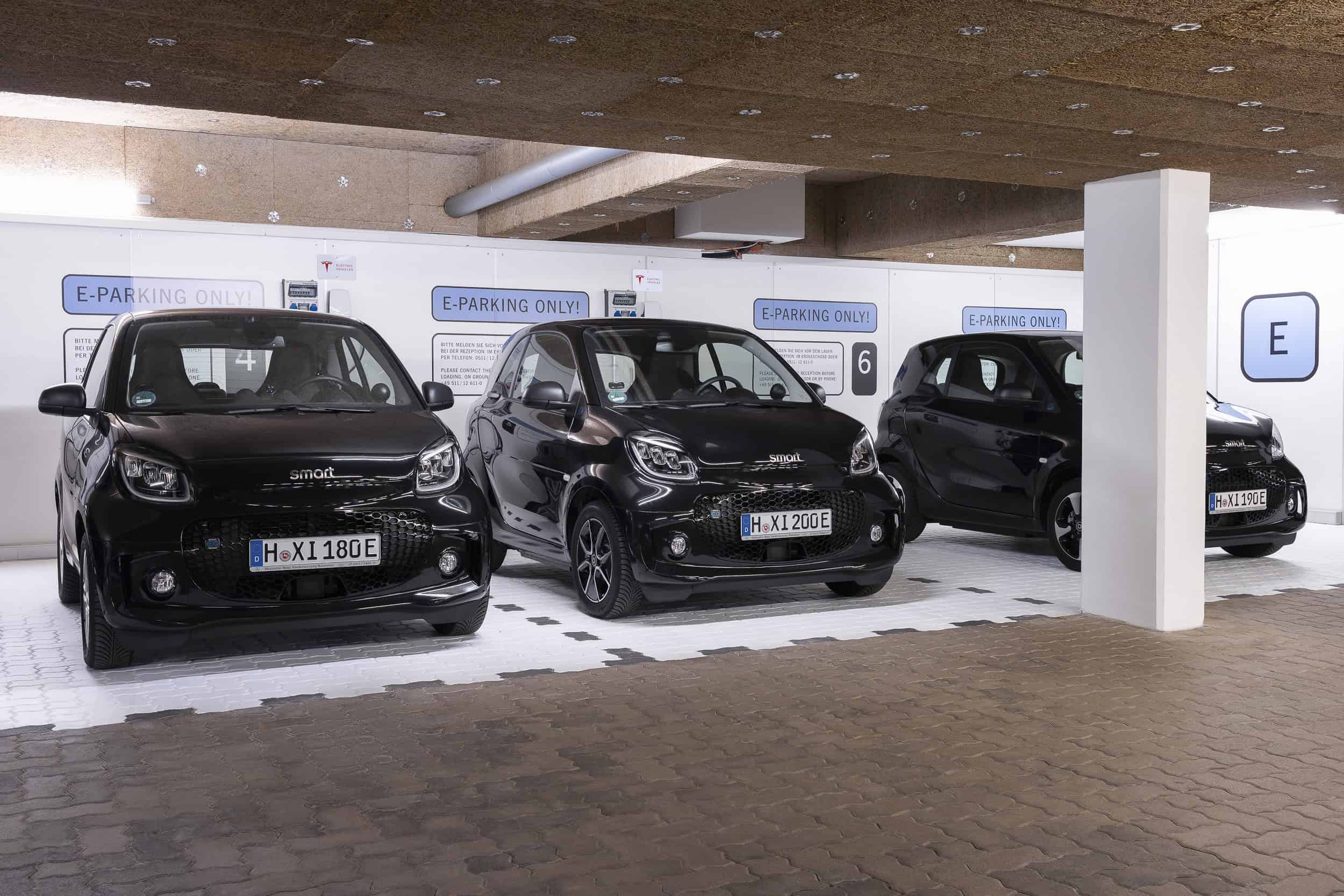 Drei "EQ Smart fortwo" Elektrofahrzeuge in den Ladestationen der Tiefgarage