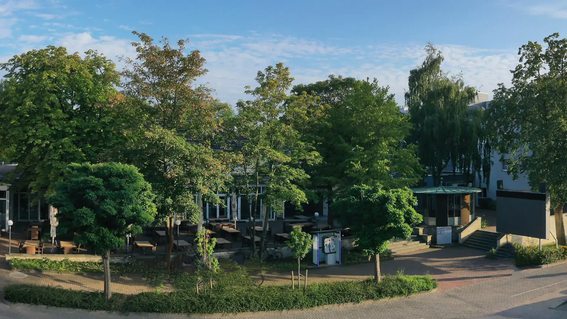 Designhotel Wienecke XI surrounded by lush greenery with an inviting outdoor area.