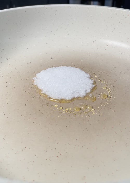 adding white sugar to the pan
