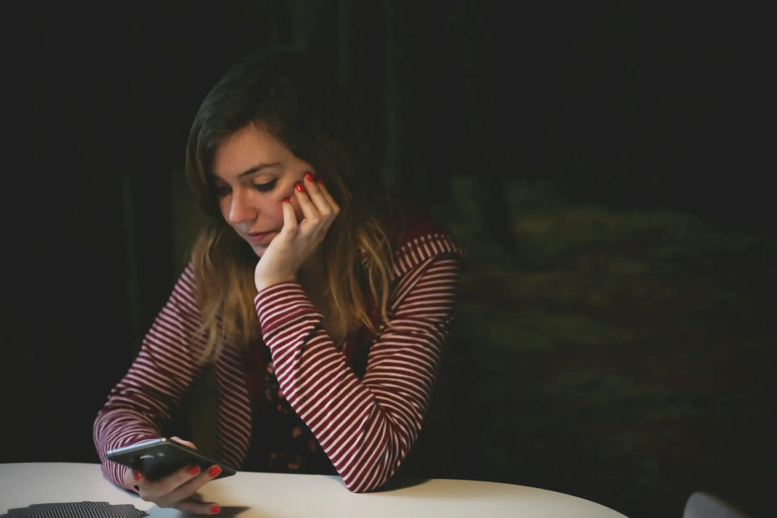 A woman looking down with concern at her phone.
