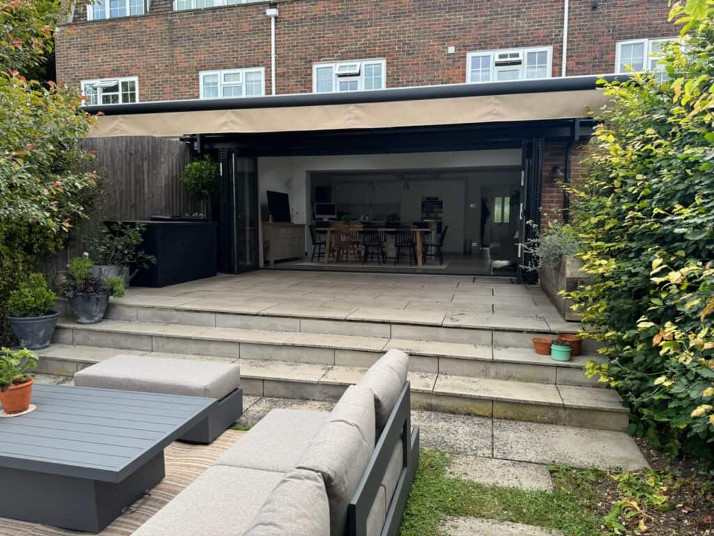 a retractable awning providing shade to patio with bifold doors