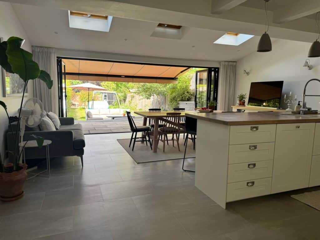 Motorised patio awning providing shade over bifold doors