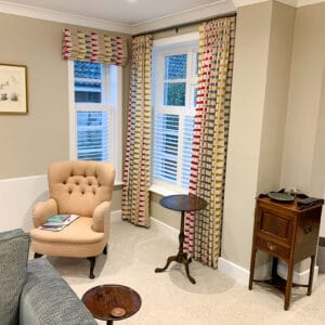 Café shutters and Roman blinds creating a layered window treatment