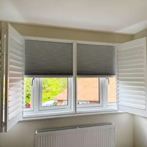 Blackout bedroom solution with plantation shutters and integrated honeycomb blind in Hampshire home