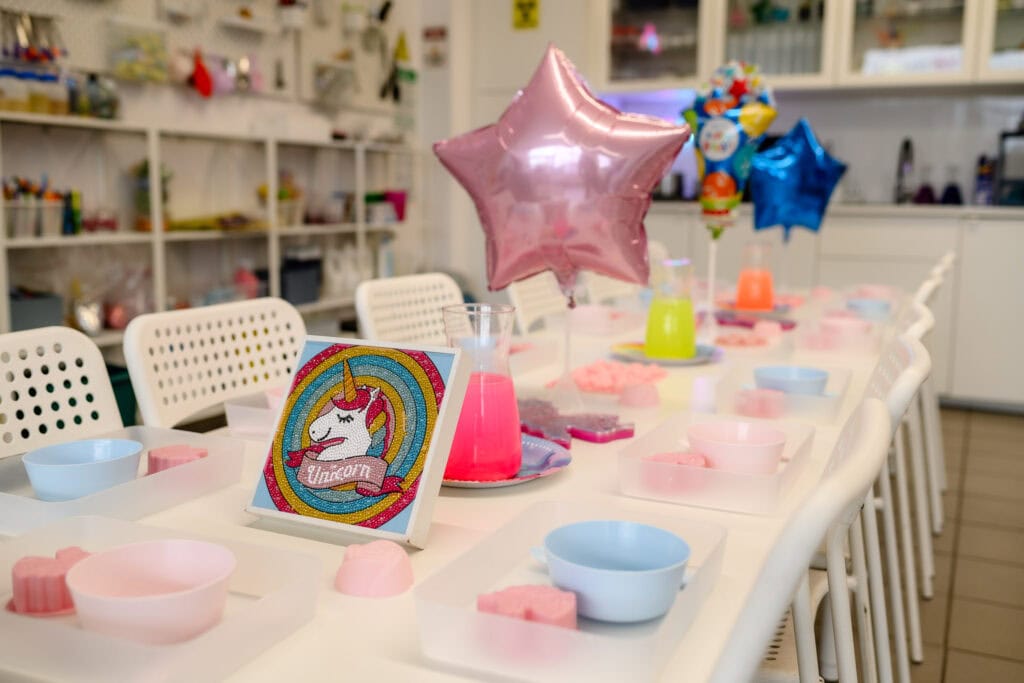 Unicorn i balony na urodzinowym stole w kolorach różu, błękitu i zieleni, dekoracje na imprezę dziecięcą, aranżacja pokoju dziecięcego, dekoracje na przyjęcie urodzinowe dla dzieci, stylizacja imprez dla dziewczynek.