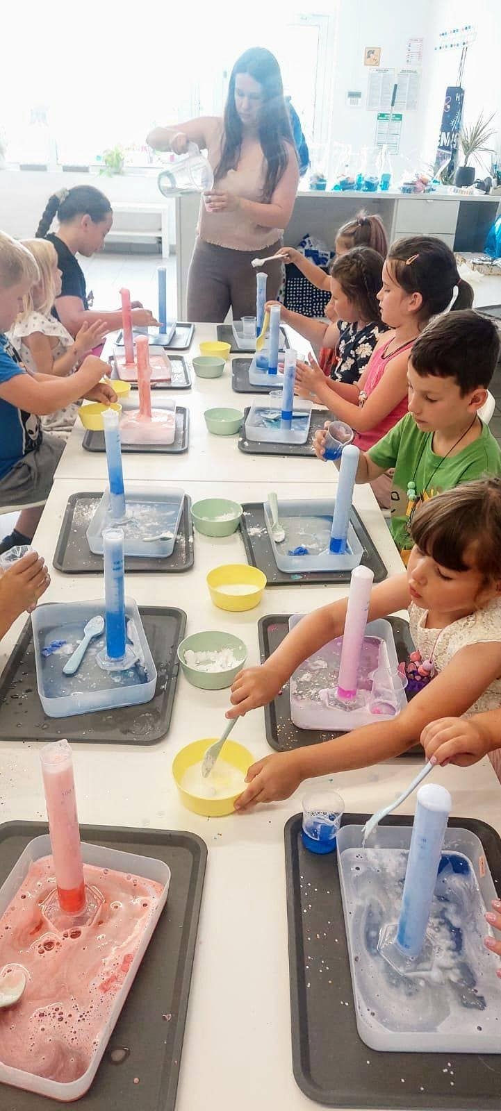 Kolorowe doświadczenia naukowe dla dzieci w laboratorium, ucząc ich podstaw chemii i fizyki poprzez eksperymenty z kolorowym mlekiem i środkami chemicznymi.