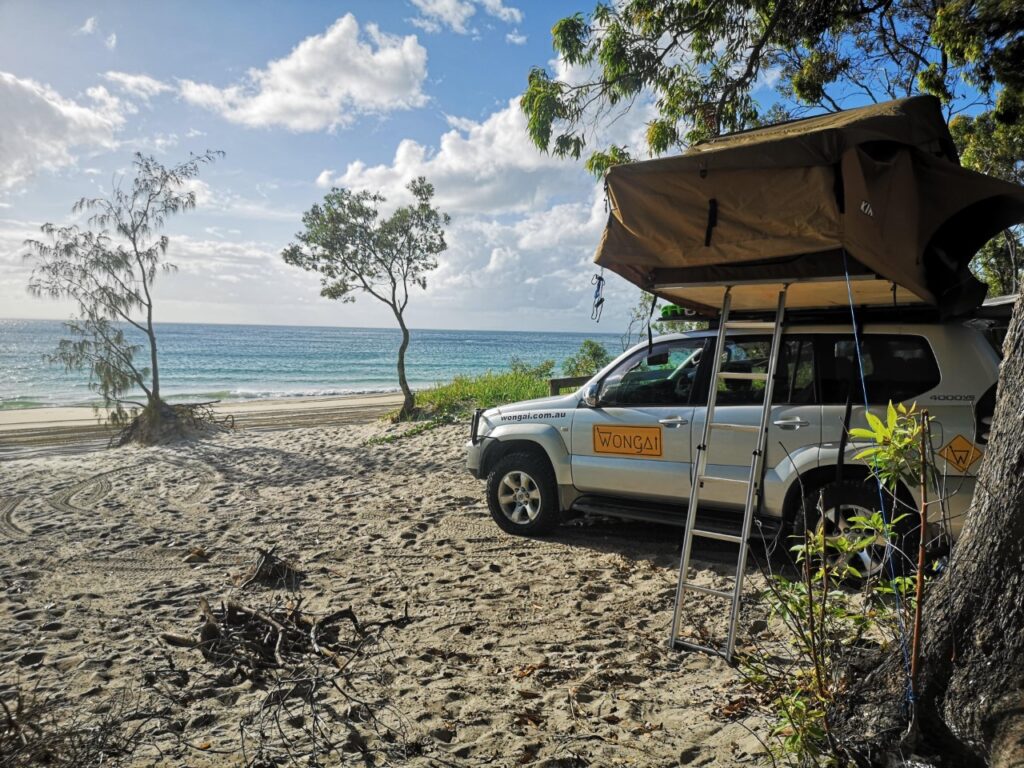 Island 4wd Hire - car sitting on beach with camper tent overhead