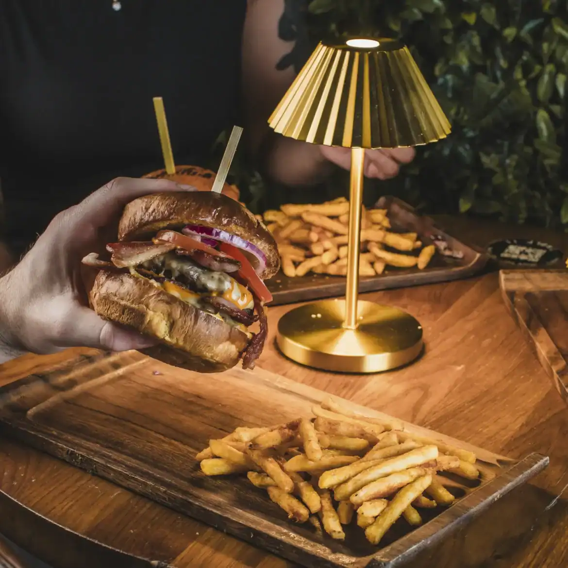 Belushi's branded loaded burgers with fries at the table, unapologetically indulgent match day food served across Belushi's World Cup sports bars in Europe