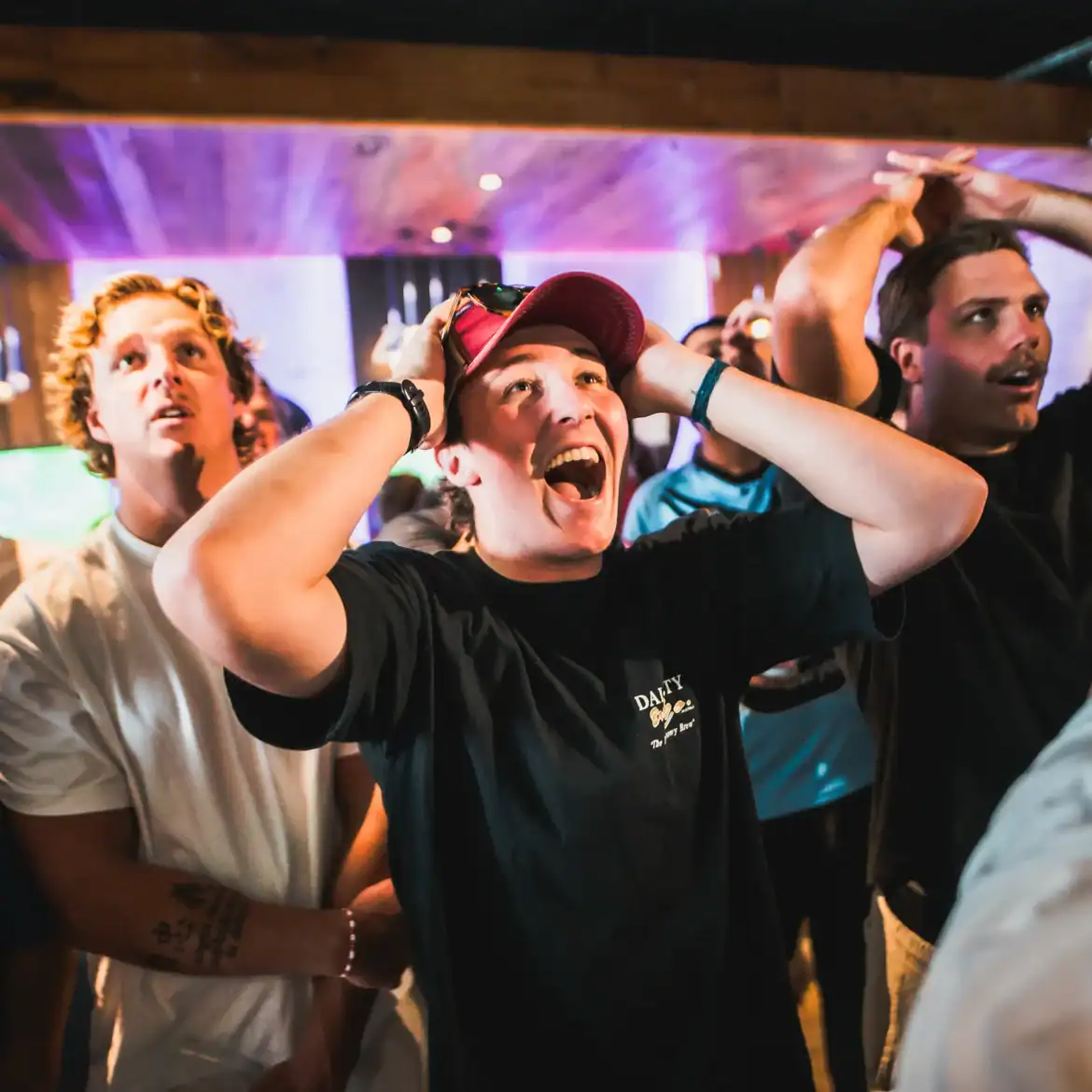 Football fan reacting to a big moment watching live football on a big screen at Belushi's sports bar, the electric atmosphere only a live match can create