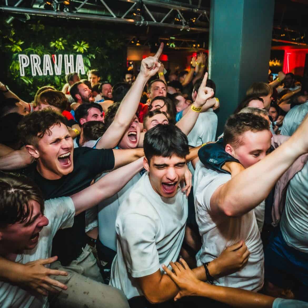 England fans cheering and pointing at Belushi's Newquay during a World Cup 2026 watch party, with a sold-out crowd packing the sports bar for the live football screening