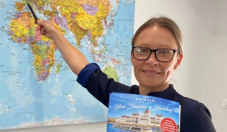 LeeAnne from WorldLee Journeys pointing to a world map, showcasing her passion for creating memorable journeys across the globe.