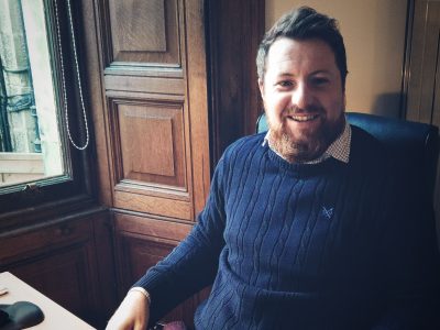 A professional architect working in a classic wood-paneled office, showcasing modern architectural office solutions.