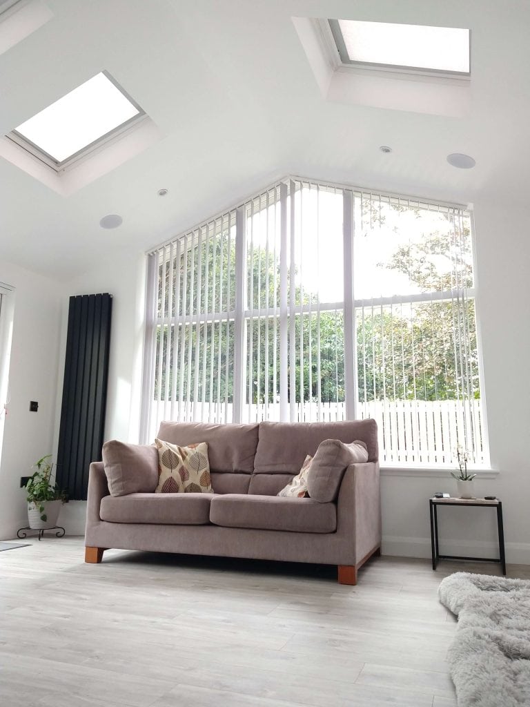 Bright living space with expansive windows, beige sofa, and contemporary interior design.