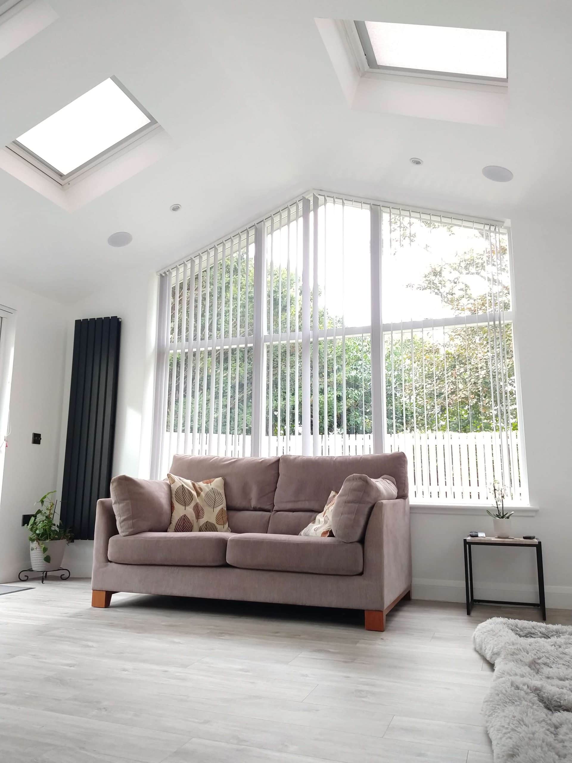 Bright living space with expansive windows, beige sofa, and contemporary interior design.