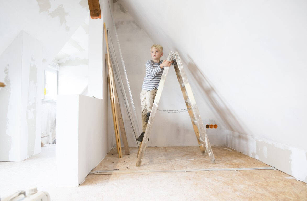Child on ladder in attic renovation, home extension.