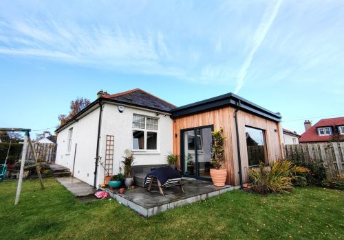 Contemporary garden room extension with timber exterior and large sliding glass doors, designed for outdoor living.