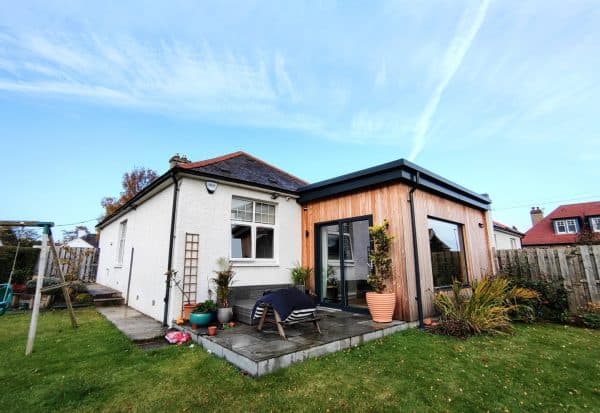 Contemporary garden room extension with timber exterior and large sliding glass doors, designed for outdoor living.