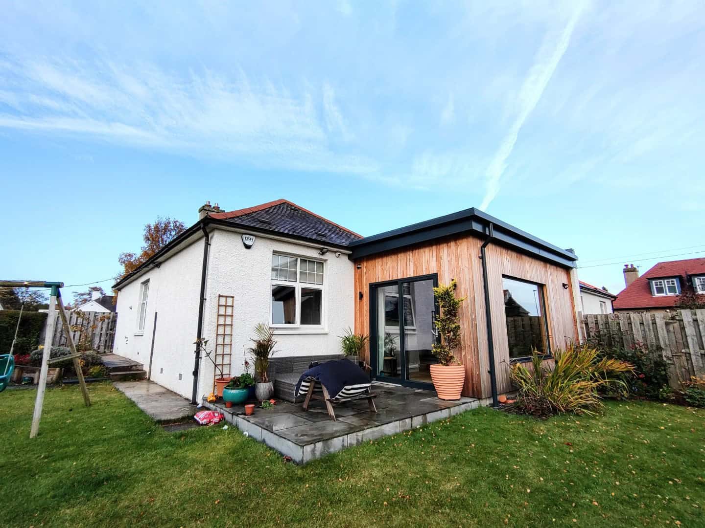 Contemporary garden room extension with timber exterior and large sliding glass doors, designed for outdoor living.